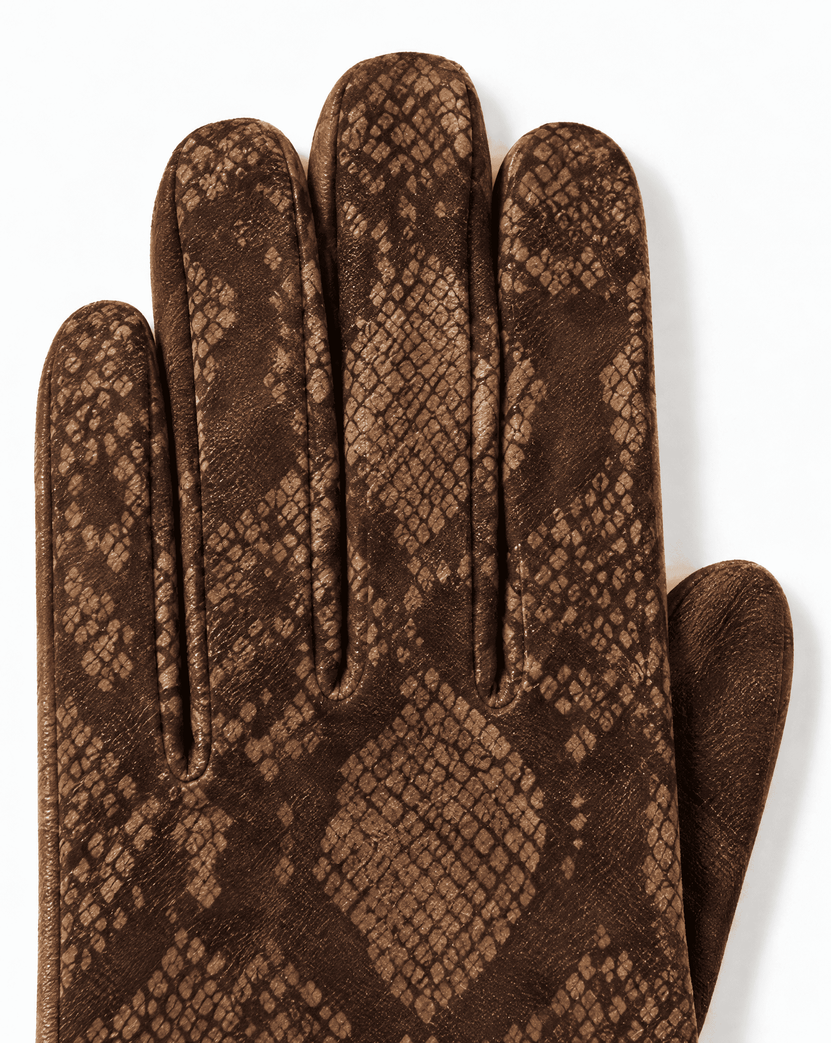 a close-up of brown suede printed with a python pattern across the fingers